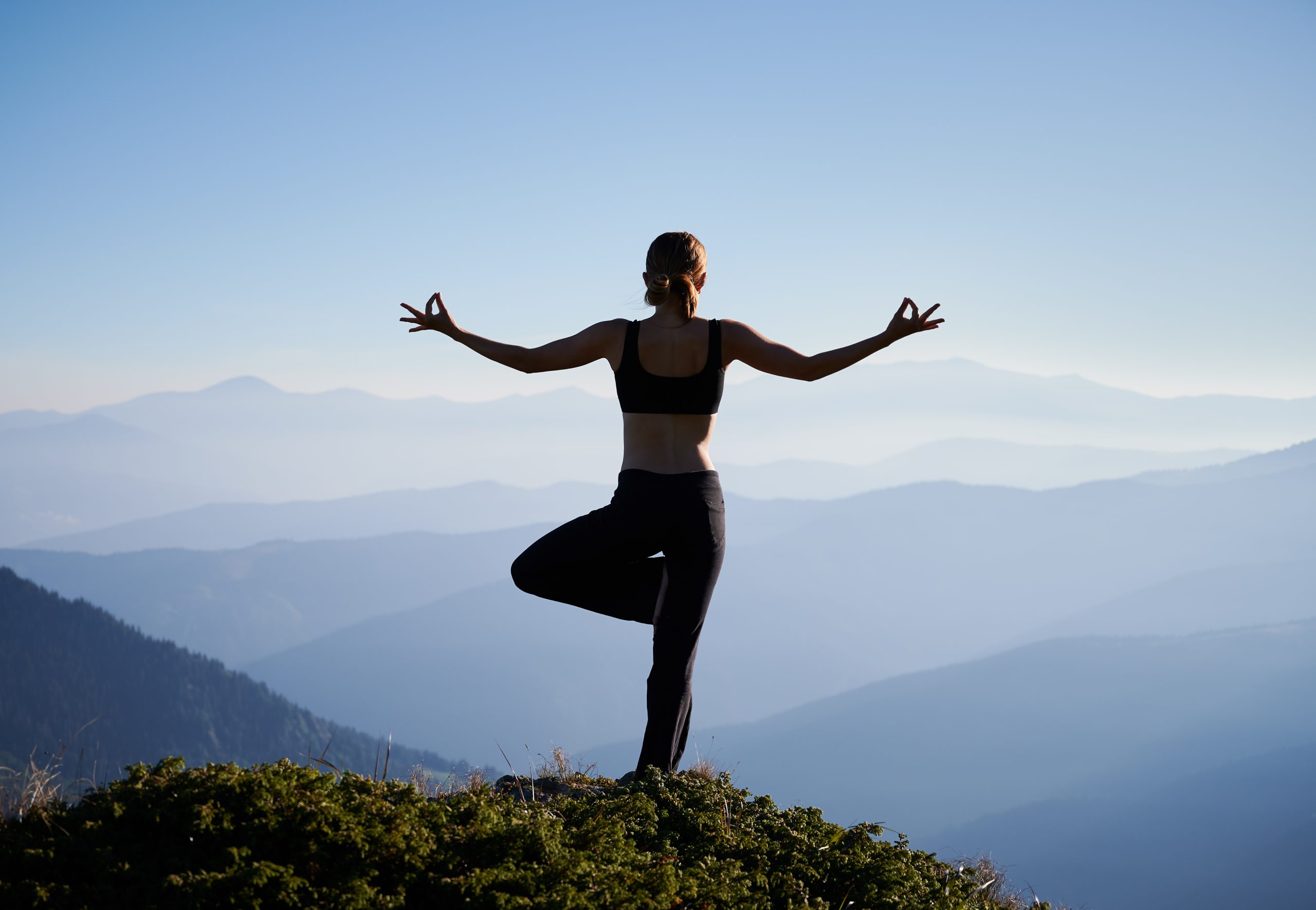 lady-doing-yoga-at-the-top-of-hill