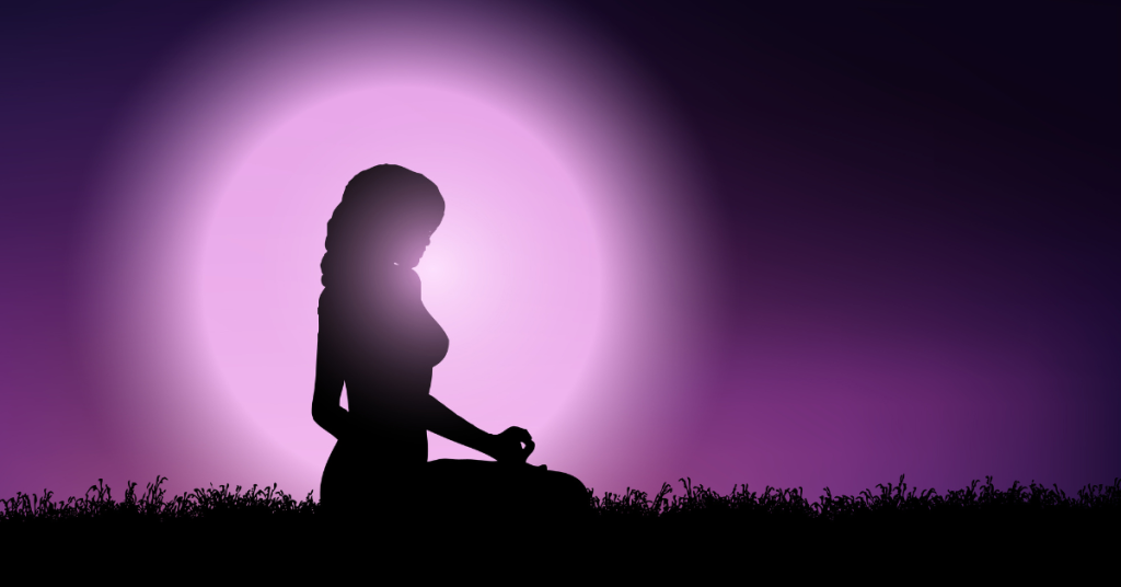 A girl practices lunar yoga, sitting on the grass serenely in front of the glowing moon.