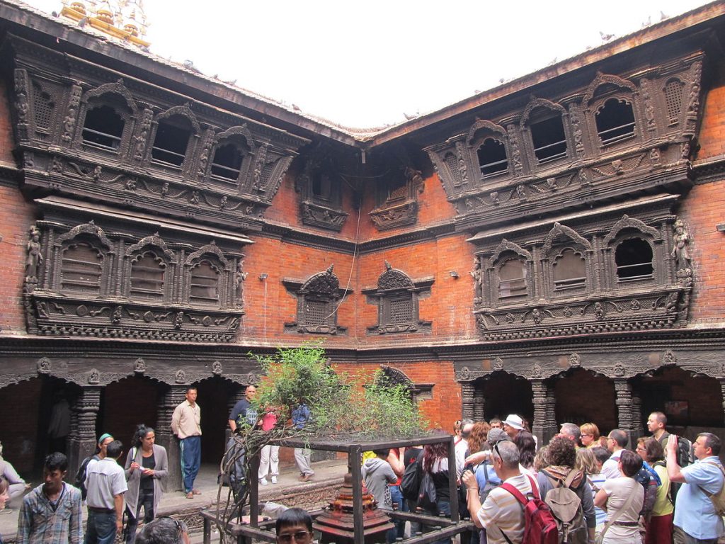 the picture is about the house of the living goddess of Nepal known as "Kumari" where we can see the statue and different people and tourist are waiting to see the living goddess "Kumari"  the architecture of the Kumari's house is different than others.